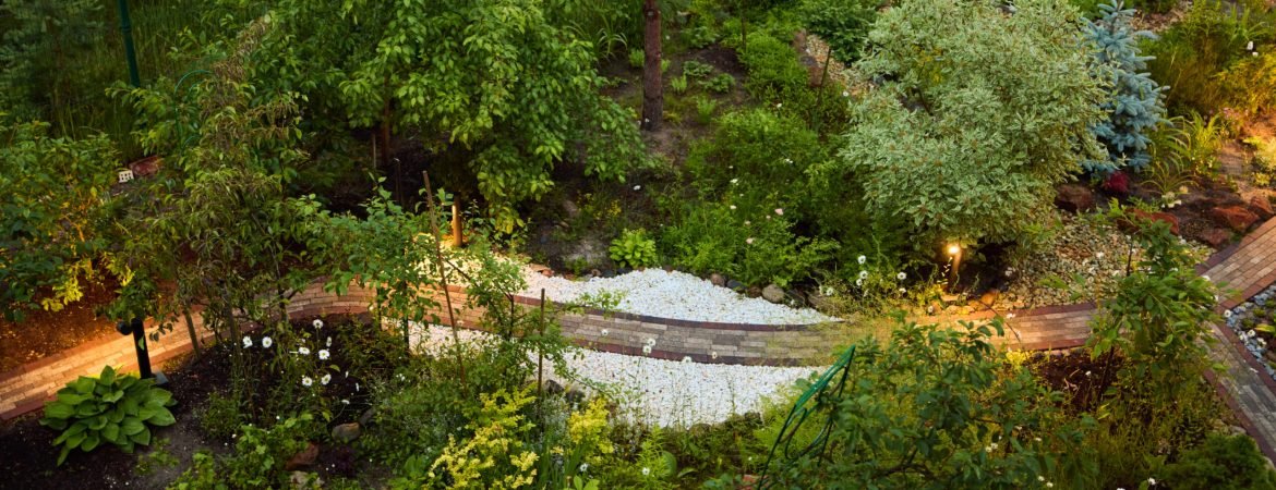 A serene and tranquil garden featuring a meandering path that flows through vibrant greenery and soft evening light